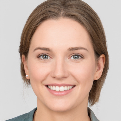 Joyful white young-adult female with medium  brown hair and grey eyes