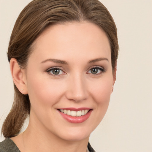 Joyful white young-adult female with medium  brown hair and grey eyes