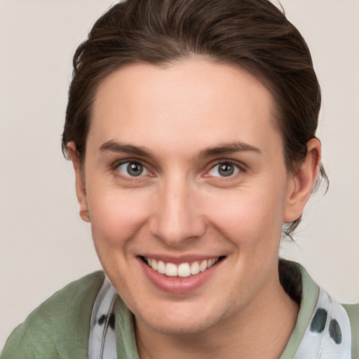 Joyful white young-adult female with medium  brown hair and grey eyes