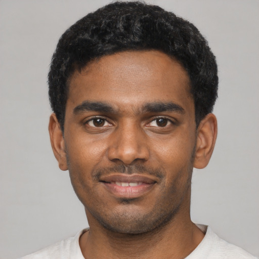 Joyful black young-adult male with short  black hair and brown eyes