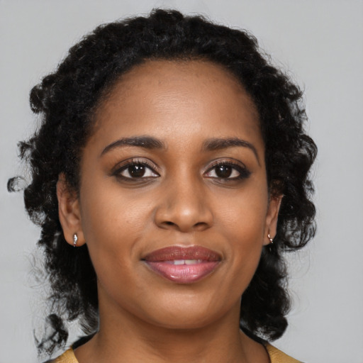 Joyful black young-adult female with medium  brown hair and brown eyes
