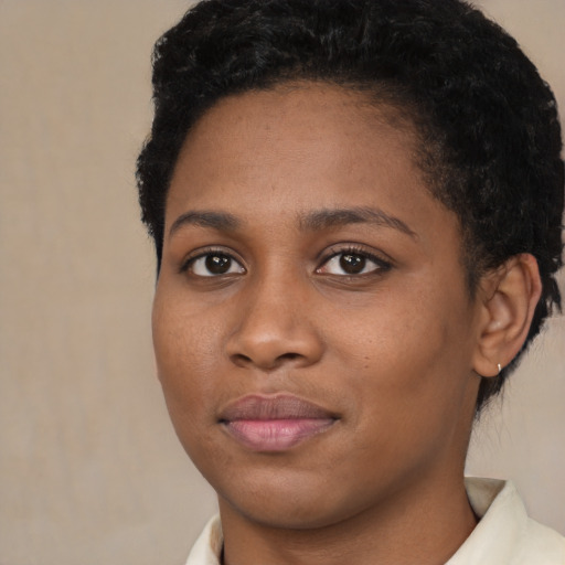 Joyful black young-adult female with short  brown hair and brown eyes