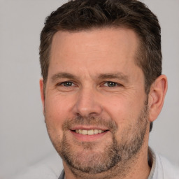 Joyful white adult male with short  brown hair and brown eyes