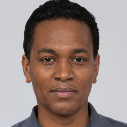 Joyful black young-adult male with short  black hair and brown eyes