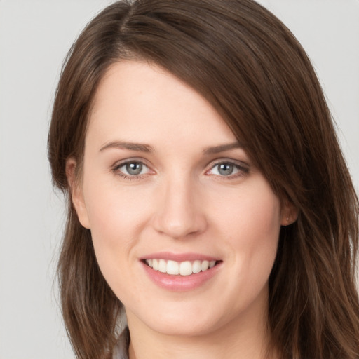 Joyful white young-adult female with long  brown hair and grey eyes