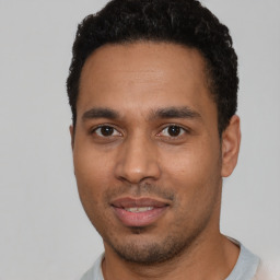 Joyful latino young-adult male with short  black hair and brown eyes