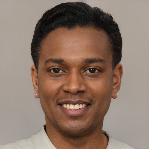 Joyful black young-adult male with short  black hair and brown eyes