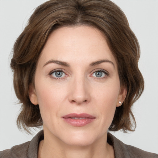 Joyful white young-adult female with medium  brown hair and grey eyes