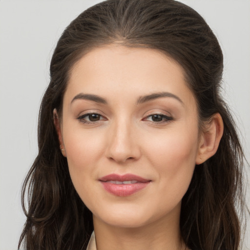 Joyful white young-adult female with long  brown hair and brown eyes