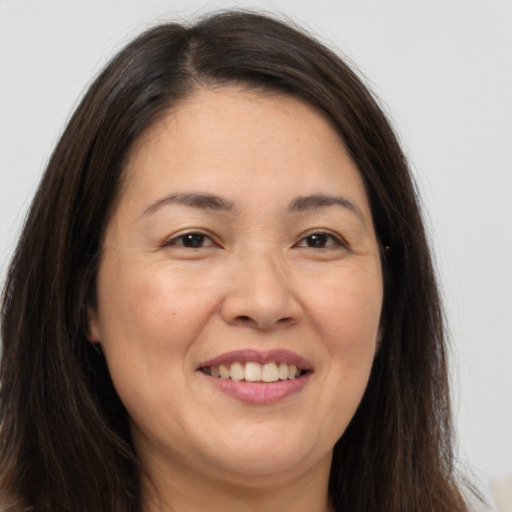 Joyful white adult female with long  brown hair and brown eyes