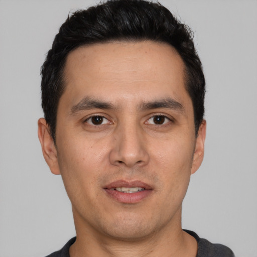 Joyful white young-adult male with short  black hair and brown eyes