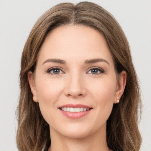 Joyful white young-adult female with long  brown hair and grey eyes