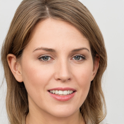 Joyful white young-adult female with long  brown hair and grey eyes