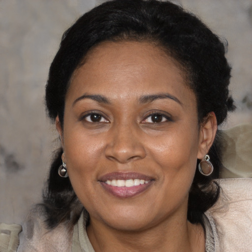 Joyful black adult female with medium  brown hair and brown eyes