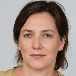 Joyful white adult female with medium  brown hair and grey eyes