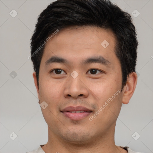 Joyful asian young-adult male with short  brown hair and brown eyes