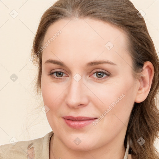 Joyful white young-adult female with long  brown hair and blue eyes