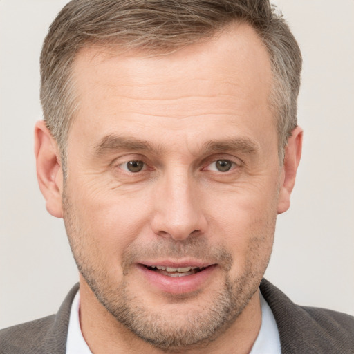 Joyful white adult male with short  brown hair and grey eyes