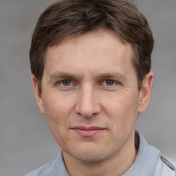 Joyful white adult male with short  brown hair and grey eyes