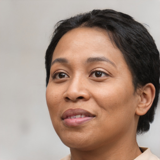 Joyful latino young-adult female with short  black hair and brown eyes