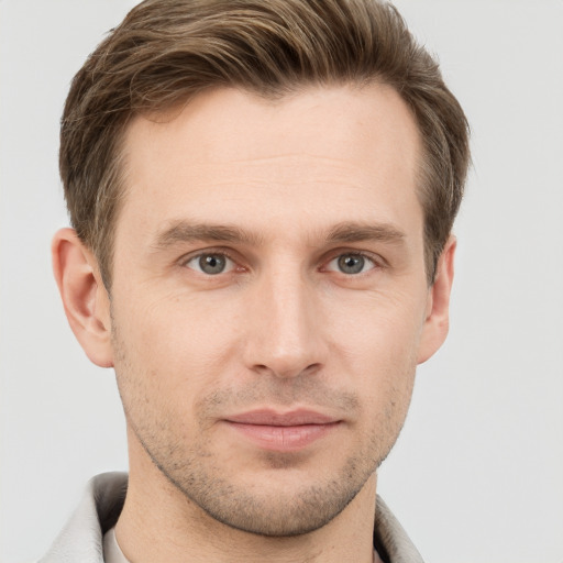 Joyful white young-adult male with short  brown hair and grey eyes