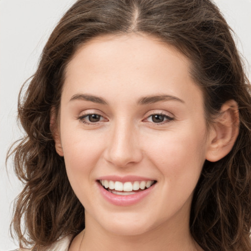 Joyful white young-adult female with long  brown hair and green eyes