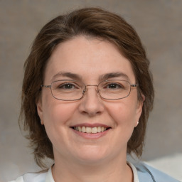 Joyful white adult female with medium  brown hair and green eyes