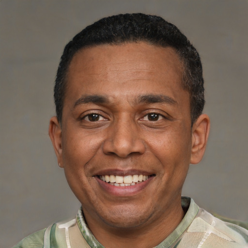 Joyful black adult male with short  black hair and brown eyes