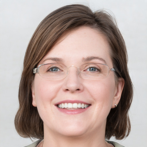 Joyful white adult female with medium  brown hair and grey eyes