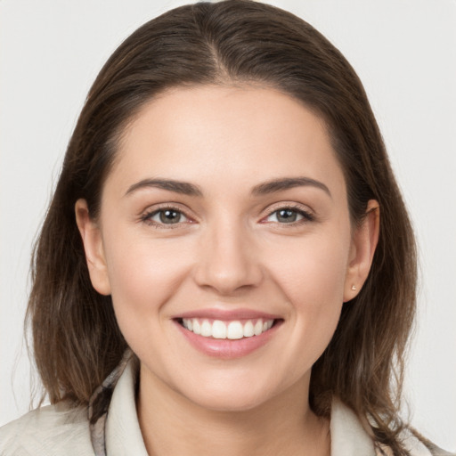 Joyful white young-adult female with medium  brown hair and grey eyes