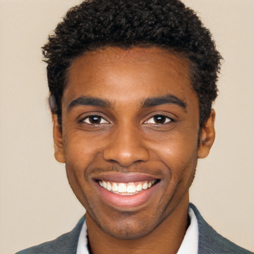 Joyful black young-adult male with short  black hair and brown eyes