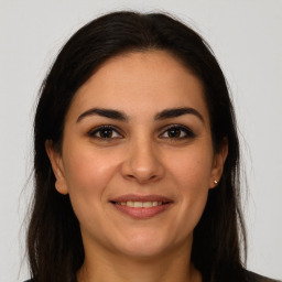 Joyful white young-adult female with long  brown hair and brown eyes