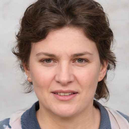 Joyful white young-adult female with medium  brown hair and blue eyes