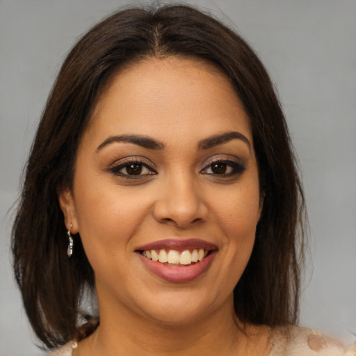 Joyful latino young-adult female with medium  brown hair and brown eyes