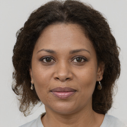Joyful black adult female with medium  brown hair and brown eyes