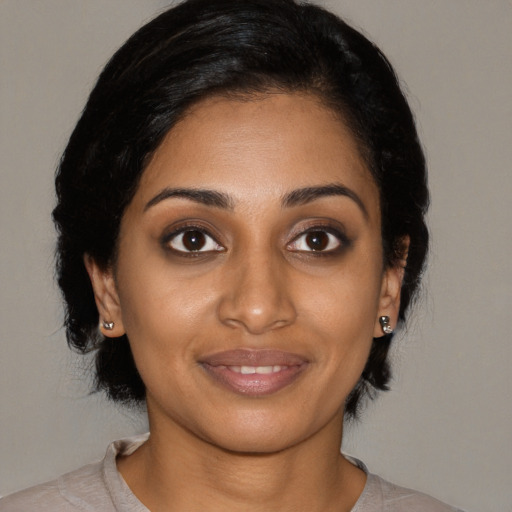 Joyful black young-adult female with medium  black hair and brown eyes