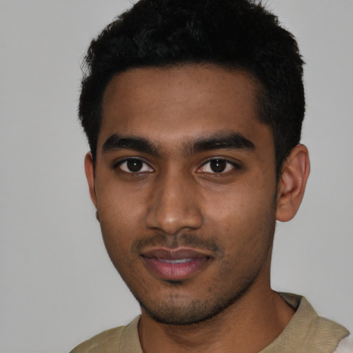 Joyful black young-adult male with short  black hair and brown eyes