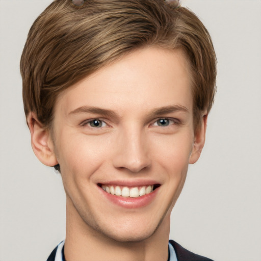 Joyful white young-adult male with short  brown hair and grey eyes