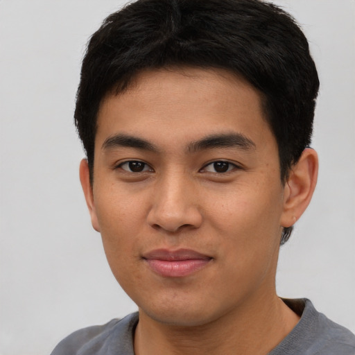 Joyful asian young-adult male with short  brown hair and brown eyes