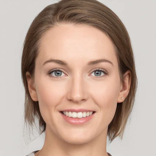 Joyful white young-adult female with medium  brown hair and grey eyes