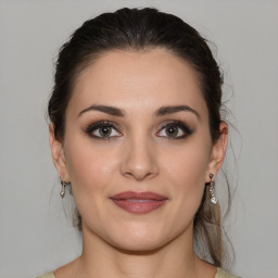 Joyful white young-adult female with medium  brown hair and green eyes