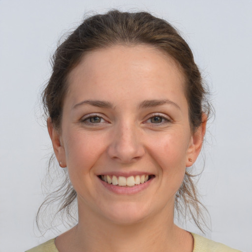 Joyful white young-adult female with medium  brown hair and grey eyes