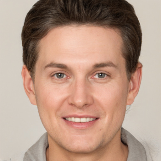 Joyful white adult male with short  brown hair and brown eyes