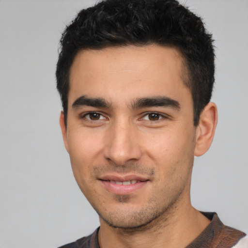 Joyful white young-adult male with short  black hair and brown eyes