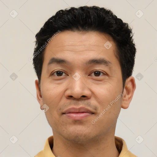 Joyful latino adult male with short  brown hair and brown eyes