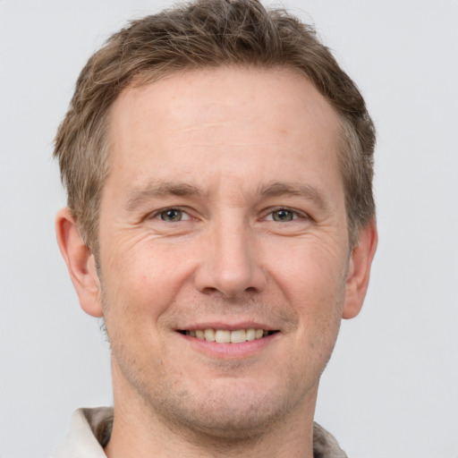 Joyful white adult male with short  brown hair and grey eyes