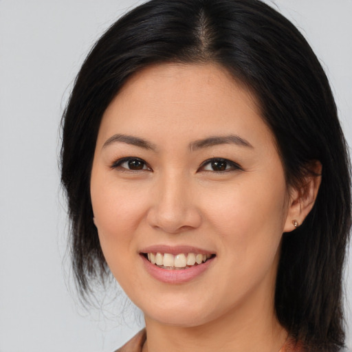 Joyful asian young-adult female with long  brown hair and brown eyes