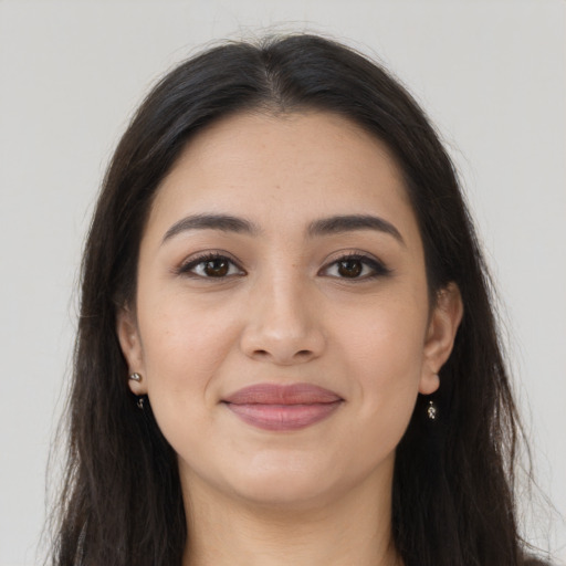 Joyful latino young-adult female with long  brown hair and brown eyes