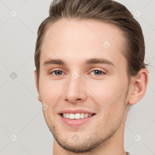 Joyful white young-adult male with short  brown hair and grey eyes