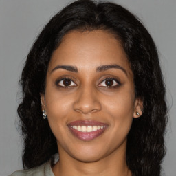 Joyful black young-adult female with long  brown hair and brown eyes